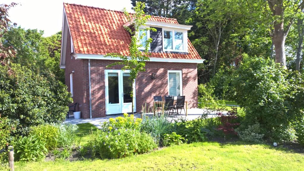 a small brick house with two chairs in a yard at Garden@Domburg in Domburg