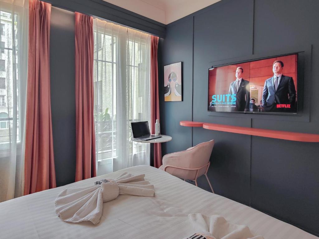 a bedroom with a bed and a tv on the wall at Aparthotel AMMI Nice Lafayette in Nice