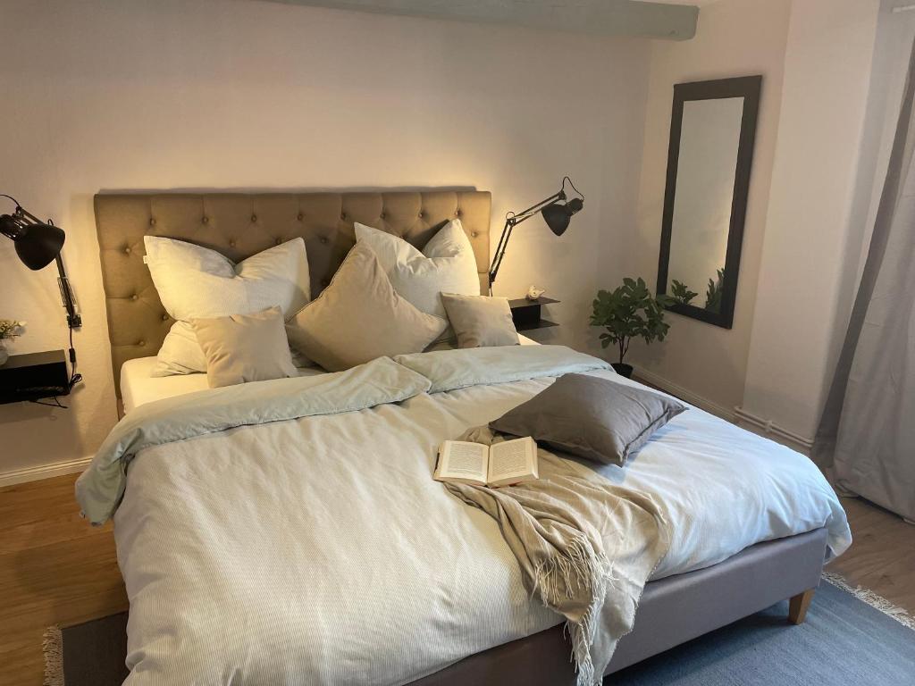 a bedroom with a large bed with a book on it at Ferienwohnung Marzipan - im Herzen der Altstadt, historisches Gebäude mit modernem Ambiente, W-LAN in Lübeck