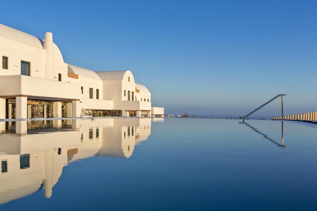 uma piscina de água em frente a um edifício em Elea Resort - Adults Only em Oia