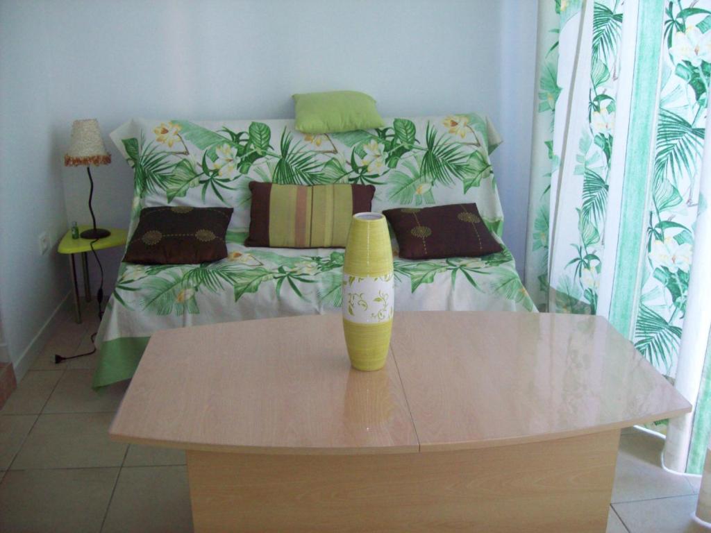 une chambre avec une table et un lit en arrière-plan dans l'établissement La Corse mer turquoise et sable fin, à Poggio-Mezzana