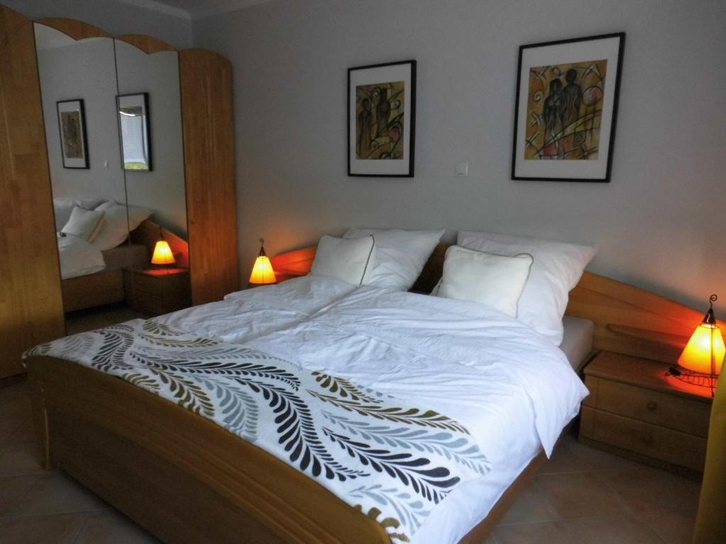 a bedroom with a large white bed with two lamps at Haus Holldack Wohnung Maria in Goldenstedt
