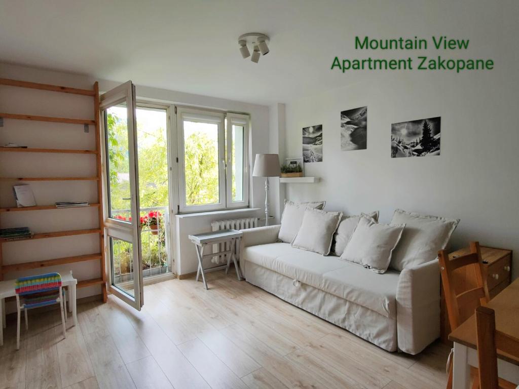 ザコパネにあるMountain View Apartment Zakopaneのリビングルーム(ソファ、テーブル付)