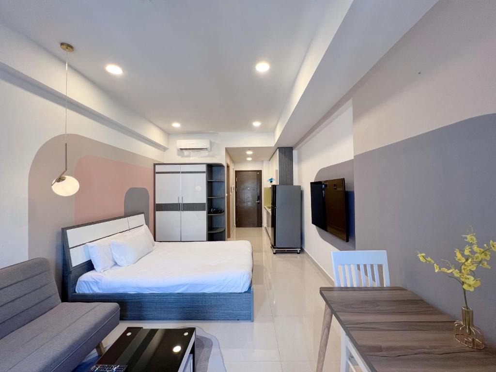 un dormitorio con una cama y un sofá en jessica' 1 bed studio condo in canter, en Ho Chi Minh