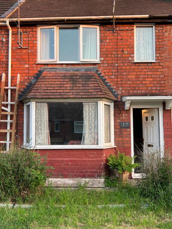 una casa de ladrillo rojo con una ventana y una escalera en Nano Rooms Accommodation en Coventry