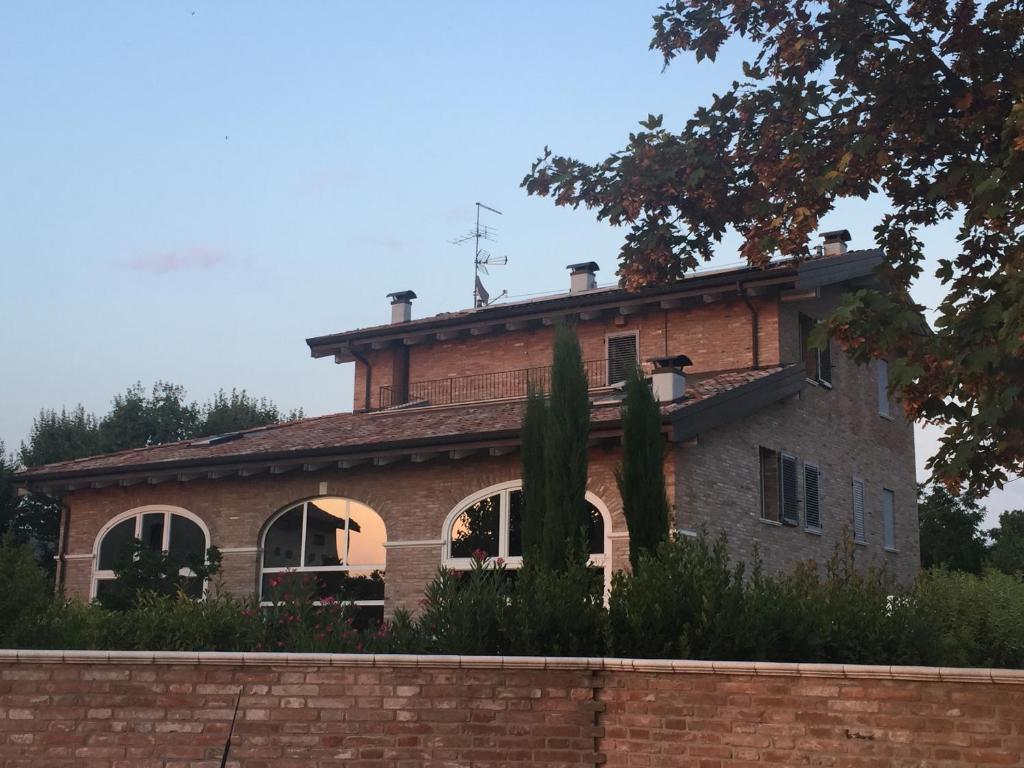 フォルミージネにあるR&B Il Melogranoの屋根付きの大きなレンガ造りの家