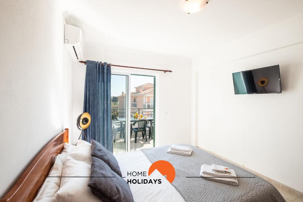 une chambre avec un lit et un balcon dans l'établissement #068 T1 Salgados by Home Holidays, à Guia