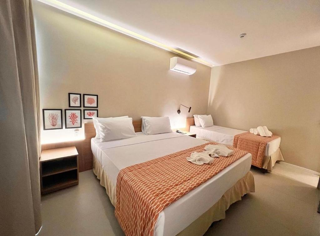 um quarto de hotel com duas camas com toalhas em Ipioca Beach Resort em Maceió