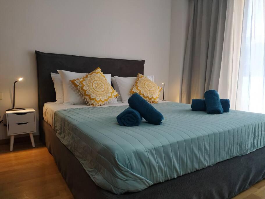 ein Schlafzimmer mit einem großen Bett mit blauen Kissen in der Unterkunft StelisIoanna in Chania