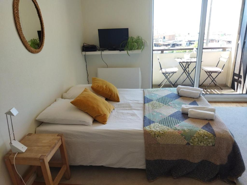 een slaapkamer met een bed met een tafel en een spiegel bij Studio ultra cosy et chic avec vue sur l'océan 3* in Seignosse