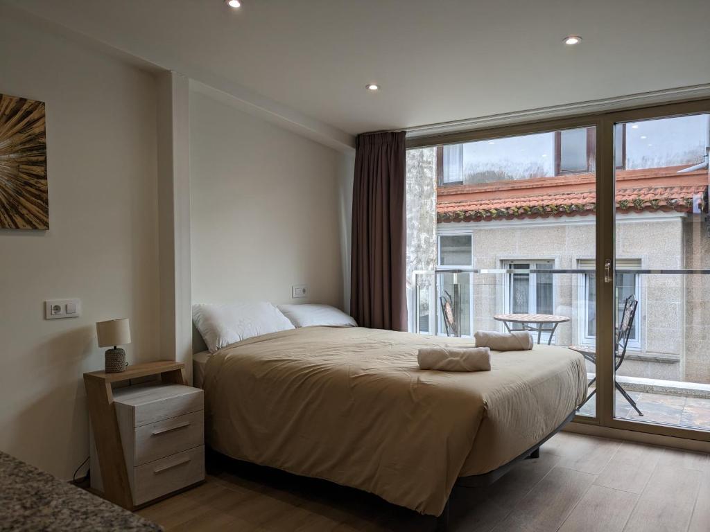 - une chambre avec un grand lit et une grande fenêtre dans l'établissement Casa Pintáns, à Cangas