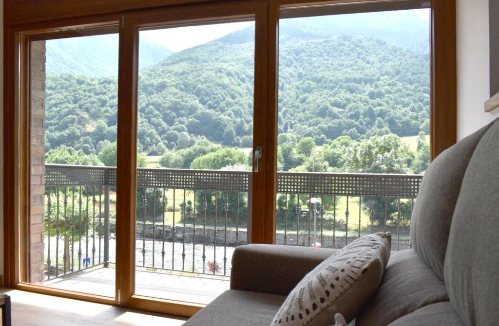 a living room with a large window with a mountain view at Apartamento Tubal in Bossost