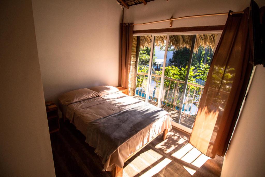 een slaapkamer met een bed voor een raam bij Kali Village in Acapulco