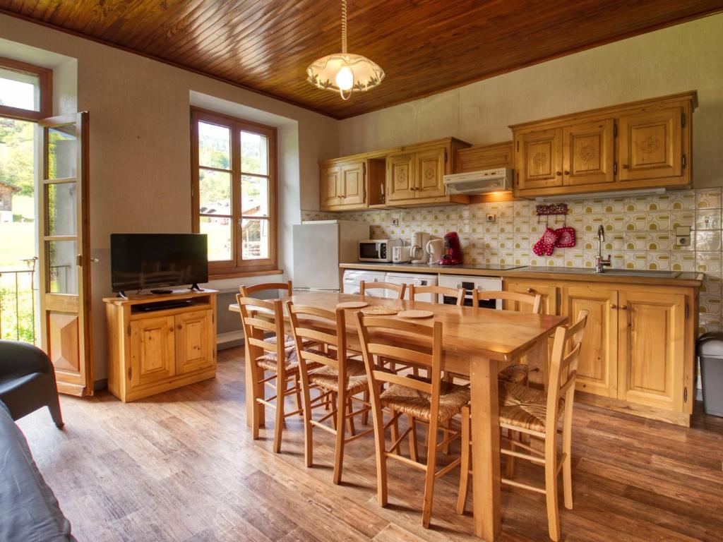 - une cuisine avec des placards en bois, une table et des chaises en bois dans l'établissement Maison Morillon Village, 4 pièces, 7 personnes - FR-1-642-13, à Morillon