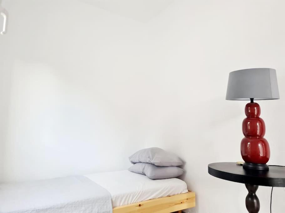 - une chambre avec un lit et une table avec une lampe dans l'établissement Nàra house 2, à Artemi