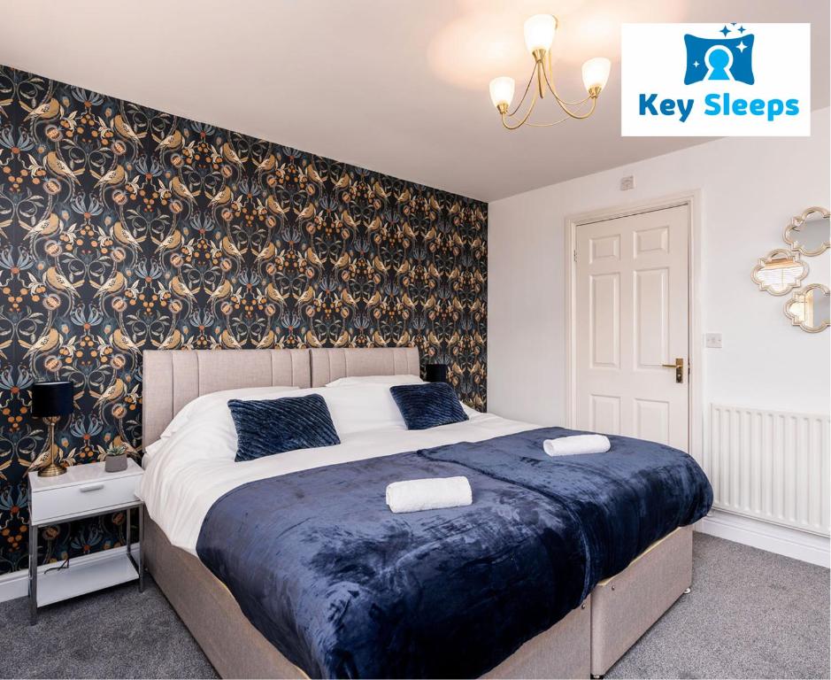 Key Sleeps- Spacious - Contractor House - Central Location - Garden - Lincolnshire في Lincolnshire: غرفة نوم مع سرير مزدوج كبير مع بطانية زرقاء