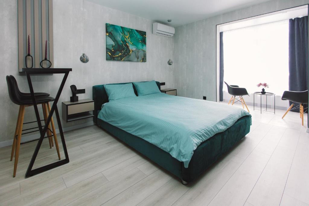 基辅Нова квартира з неймовірним краєвидом на озеро的一间卧室，里面有一张床、一张桌子和几把椅子。