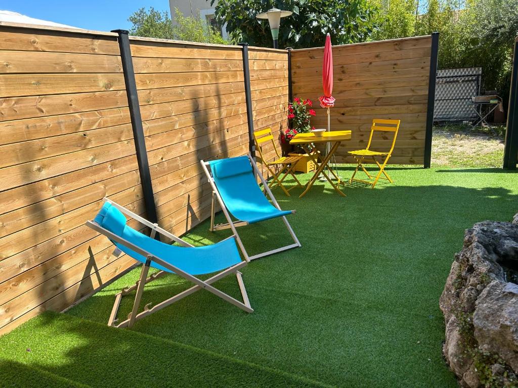 un patio avec des chaises et une table et une clôture dans l'établissement En toute intimité, à Toulon