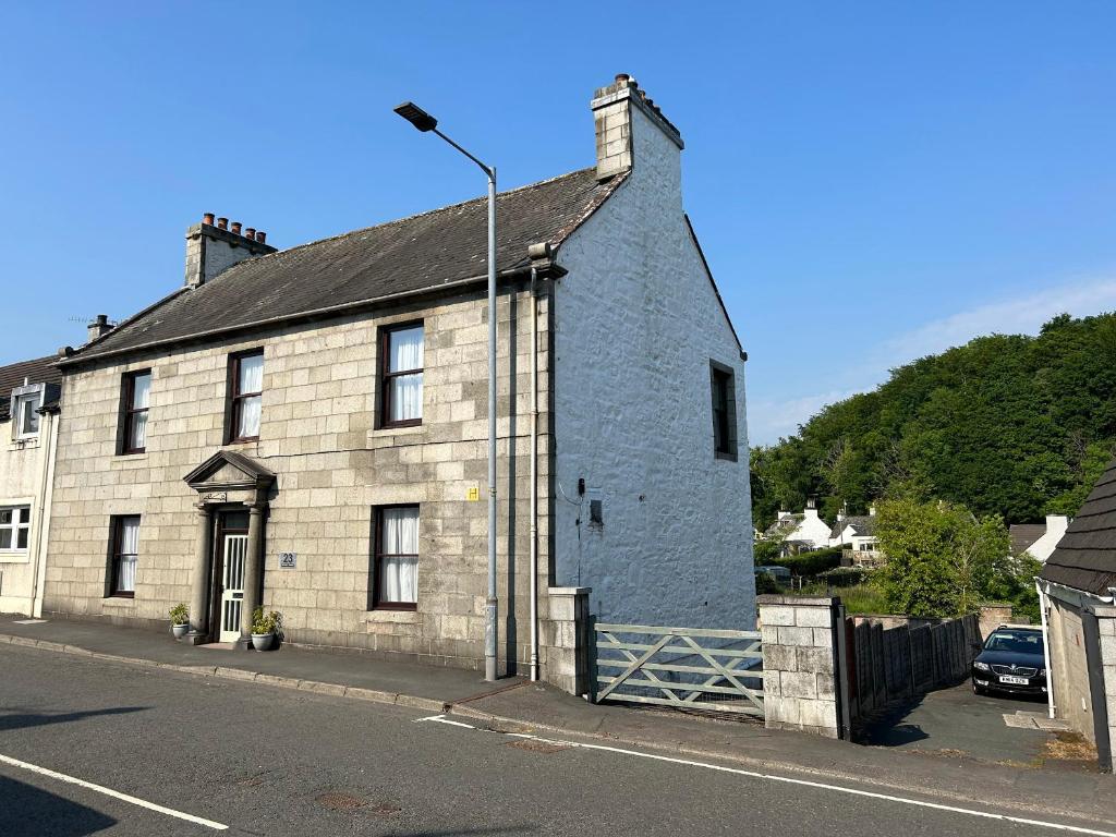 an old stone building on the side of a street at Brewery House in Newton Stewart