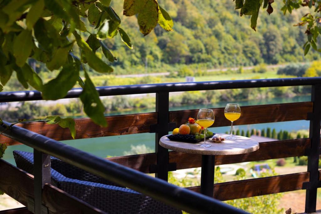 a table with two glasses of wine on a balcony at Apartment with river Una view / Ilma 2 in Bihać