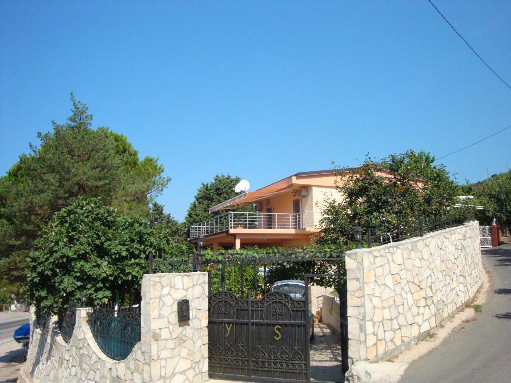 a house with a stone fence in front of a gate at Dobra Voda YSV in Dobra Voda