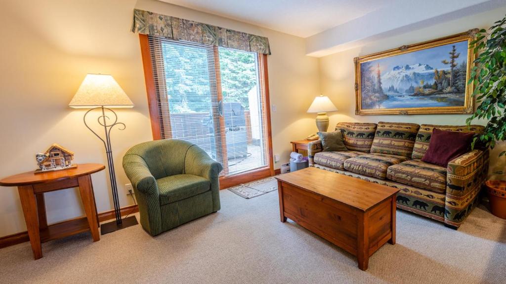 a living room with a couch and a chair at Timberline Village #38 By Bear Country in Sun Peaks