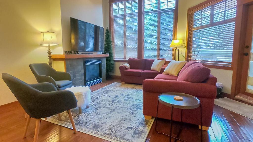 a living room with a couch and chairs and a fireplace at Settlers Crossing #29 By Bear Country in Sun Peaks