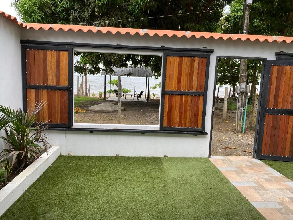 a house with a garden with a yard with green grass at Malibu beach in Punta de Piedra