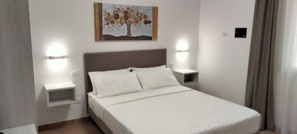 a bedroom with a white bed with two night stands at THE BEST SUITES & ROOMS - A pochi passi dalla kasbah - in Mazara del Vallo