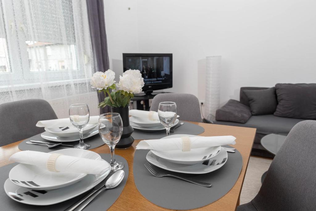 a dining room with a table with plates and wine glasses at Vacation home Ivana in Vukovar