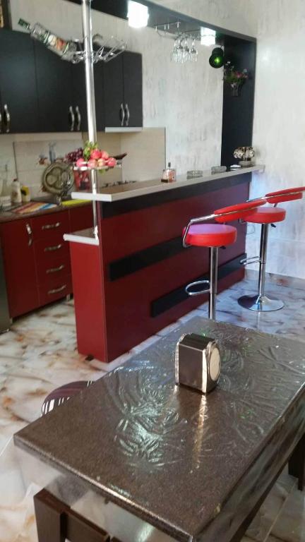 a kitchen with a table and two red stools at apartament dato in Batumi