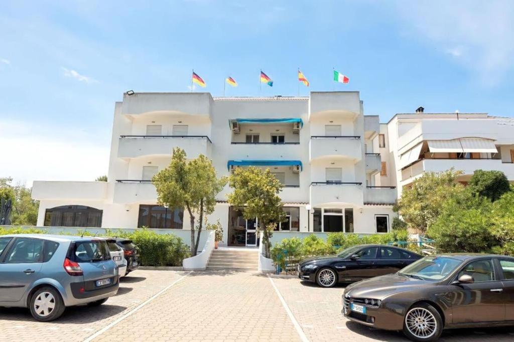 a building with cars parked in front of it at Hotel Cristalda in Vieste