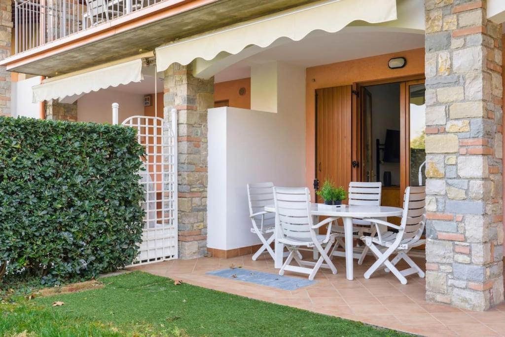 a patio with a table and chairs on a house at Relax by the pool - Garden - Garage in Polpenazze del Garda