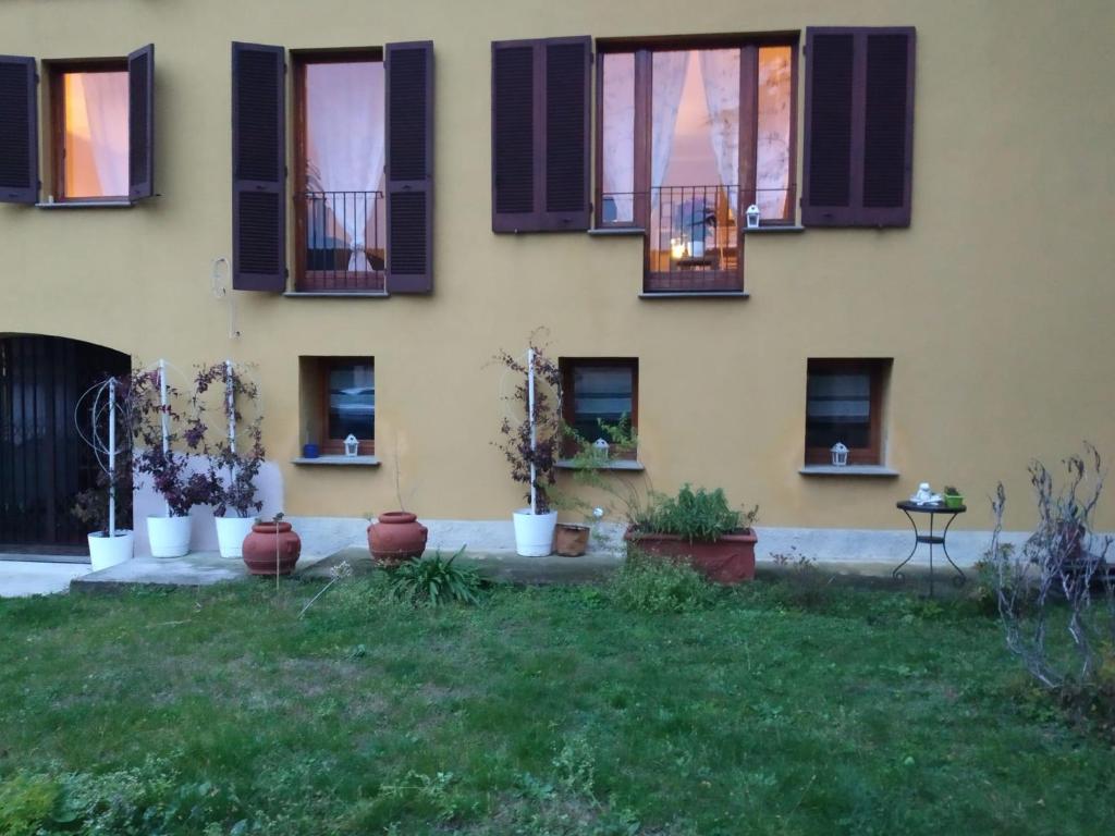 a building with windows and plants in a yard at Casa di Giò in Pettenasco