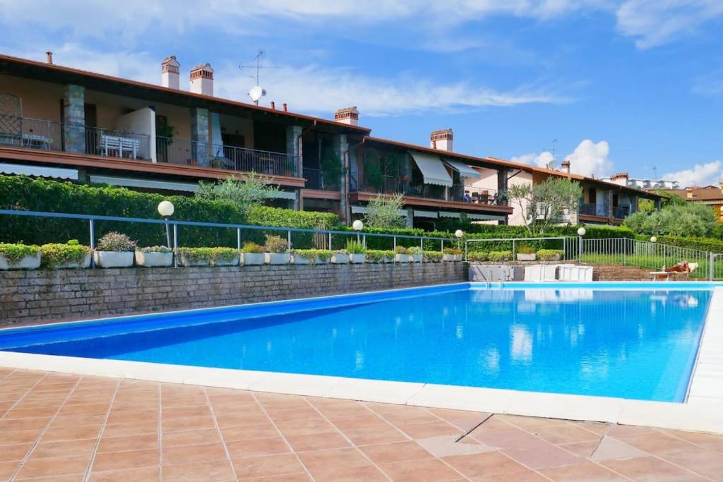 a large blue swimming pool in front of a building at Casa BELLA - POOL Garden Parking in Polpenazze del Garda