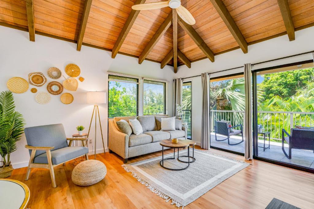 sala de estar con sofá, sillas y ventanas en Kahala 924, en Koloa