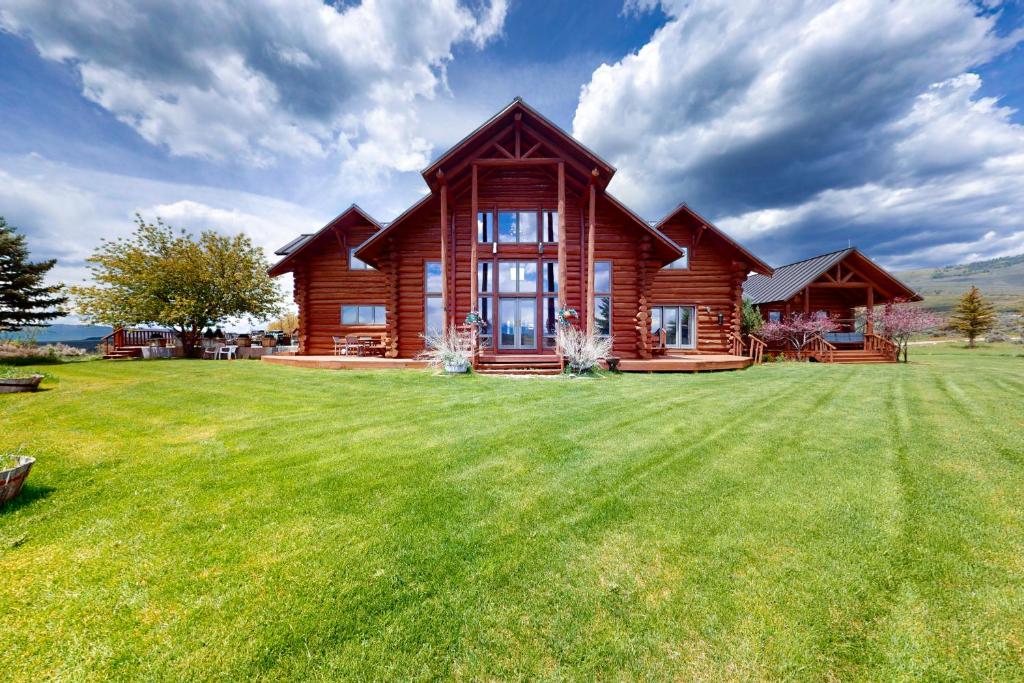 a log cabin on a large grass field at Lake Springs Luxury in Glenwood Springs