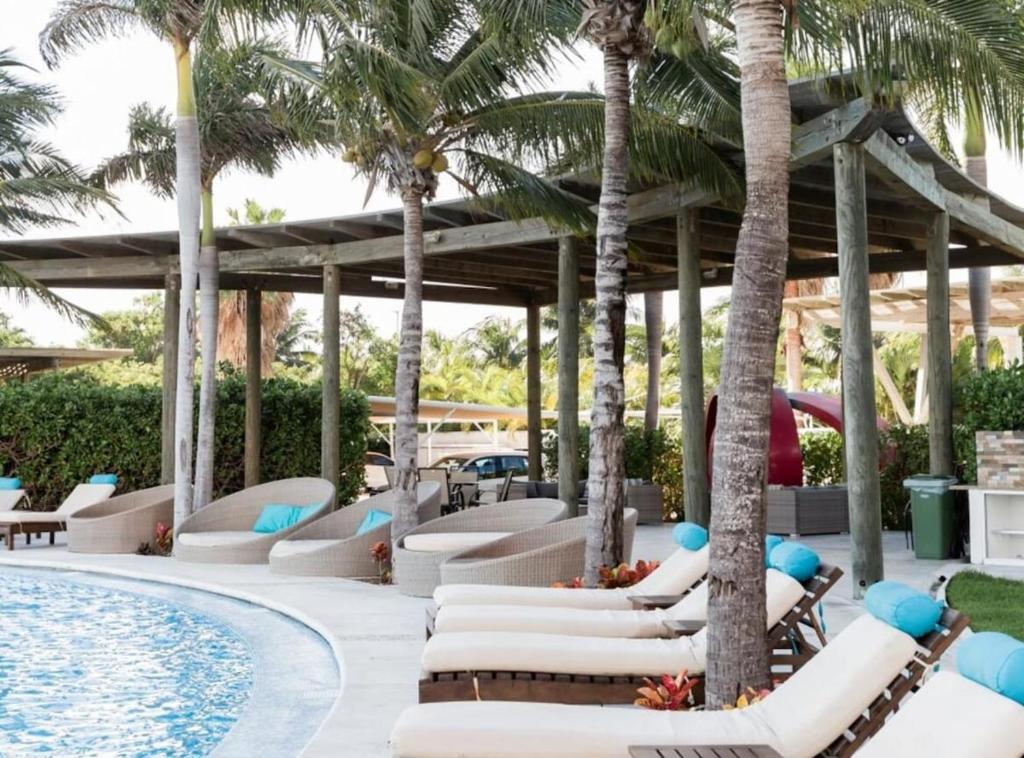 una piscina resort con tumbonas y palmeras en Ocean view 3 bedroom condo! Infinity pool, en Cancún