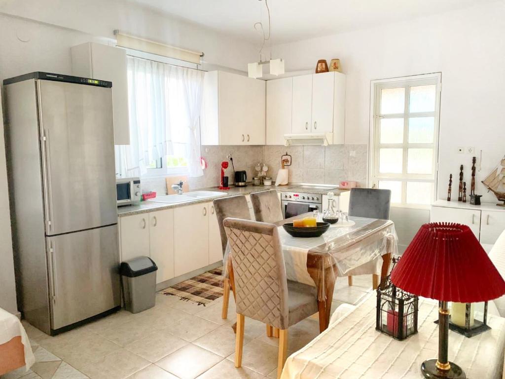 uma cozinha com uma mesa e um frigorífico de aço inoxidável em Diamond's House em Kallithea Halkidikis