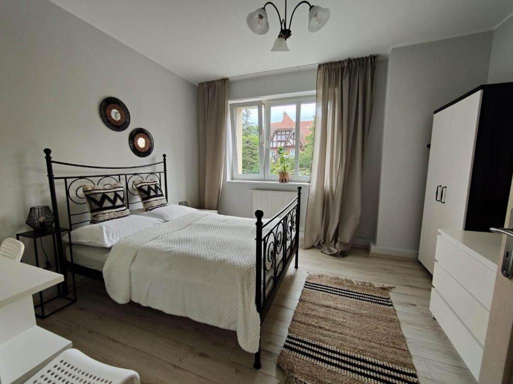 a bedroom with a black bed and a window at Apartament Armii Krajowej Sopot 71 in Sopot
