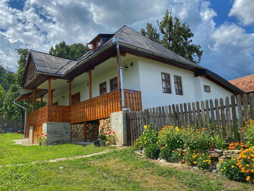 una pequeña casa blanca con una valla de madera en Casuta Bunicilor Corbii de Piatra, en Corbi