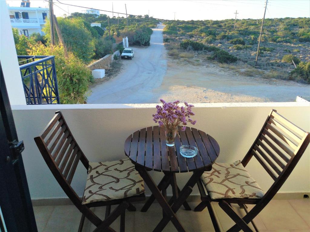 a table with a vase of flowers on a balcony at Dolphin Rooms in Antiparos
