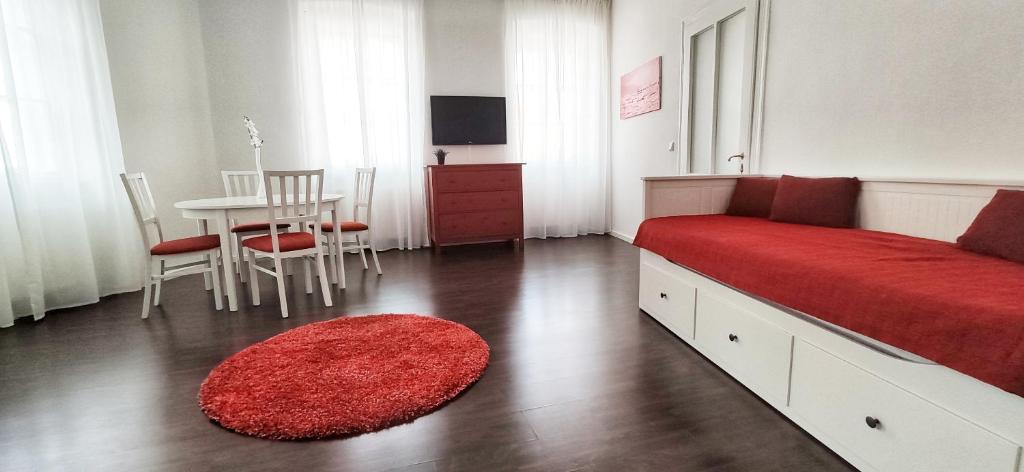 een slaapkamer met een bed en een tafel met een rood tapijt bij Helle Zweiraumwohnung in Wohngebiet in Wenen