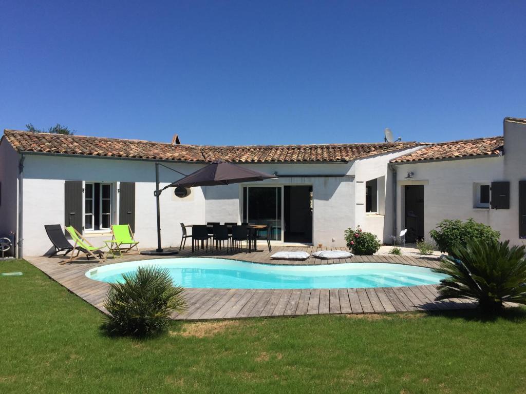 une maison avec une piscine dans la cour dans l'établissement Très belle villa, 4 chambres, piscine et jacuzzi, à Rivedoux-Plage