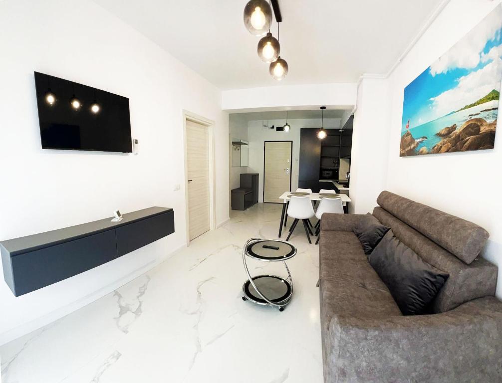 un soggiorno con divano e TV a parete di Apartament Studio Adelina WAVE 5 a Mamaia Nord - Năvodari