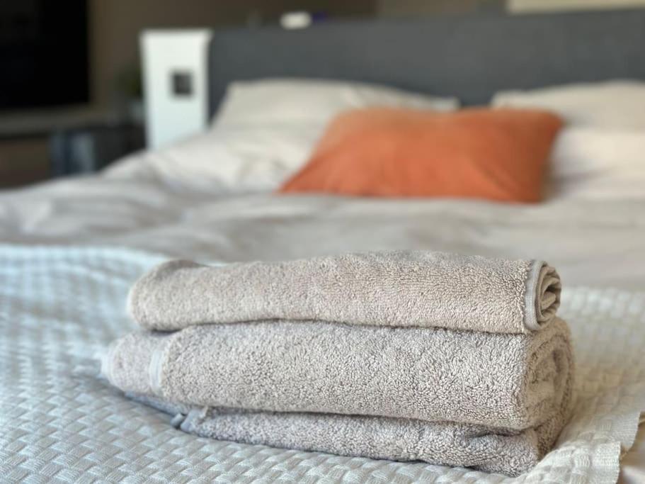 una pila de toallas sentadas encima de una cama en The Ostend Oasis, en Ostende