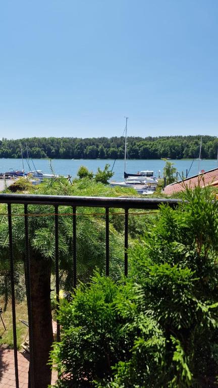 a balcony with a view of a lake and boats at Pokój z tarasem na jezioro, Mikołajki in Mikołajki