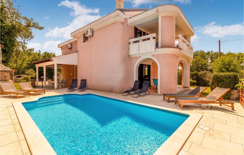 une villa avec une piscine en face d'une maison dans l'établissement Beautiful Home In Dobrinj With Outdoor Swimming Pool, à Dobrinj