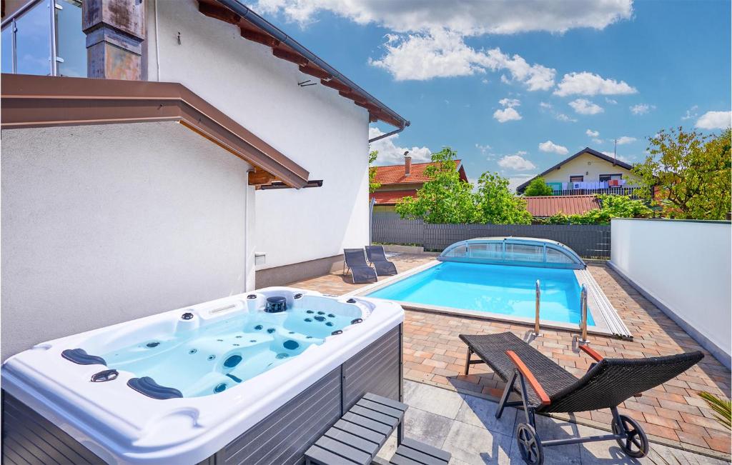 a hot tub on a patio next to a swimming pool at Awesome Home In Dugo Selo With Outdoor Swimming Pool in Dugo Selo