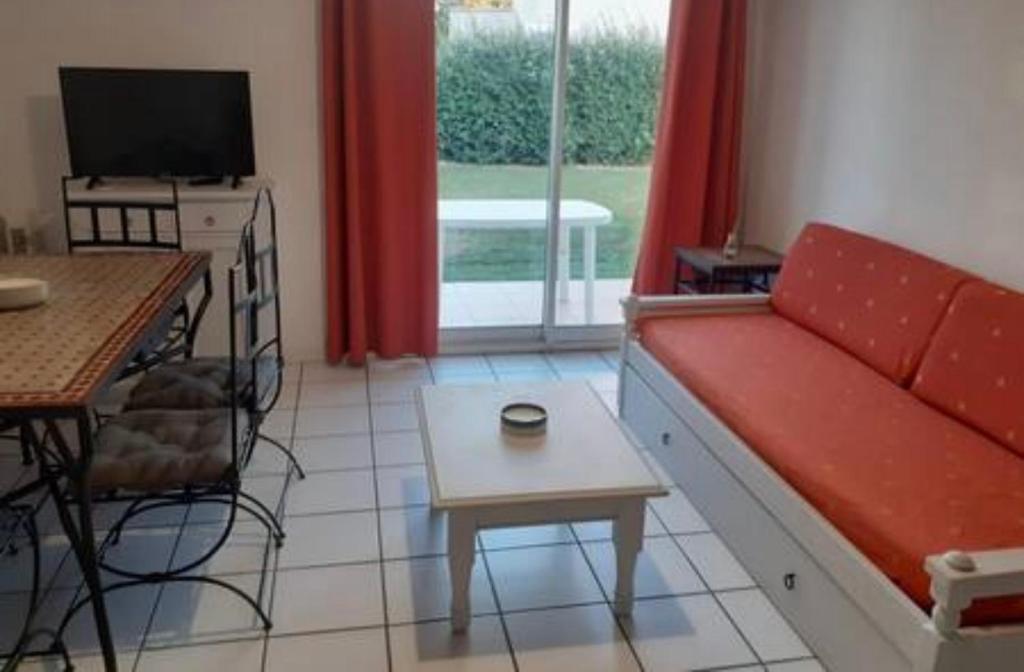 - un salon avec un canapé rouge et une table dans l'établissement Belle Maisonette dans Residence 3* avec piscine partagée, à Saint-Saturnin-lès-Avignon